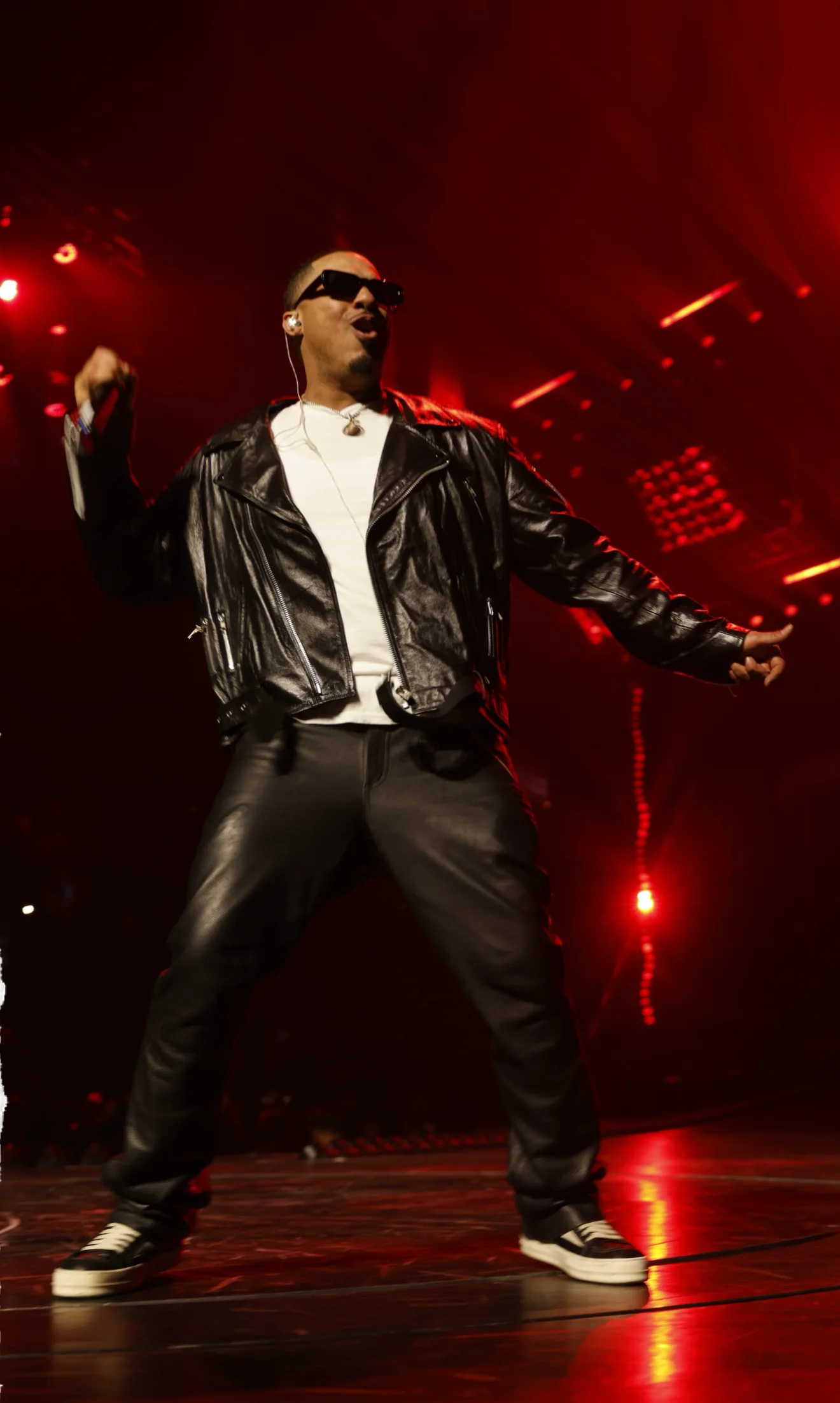 DJ Ray G hyping the room under red concert lights.